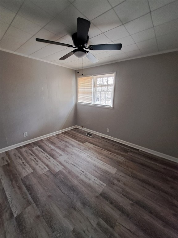 unfurnished room featuring crown molding, wood finished floors, visible vents, and baseboards