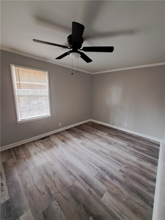 unfurnished room featuring ornamental molding, visible vents, baseboards, and wood finished floors