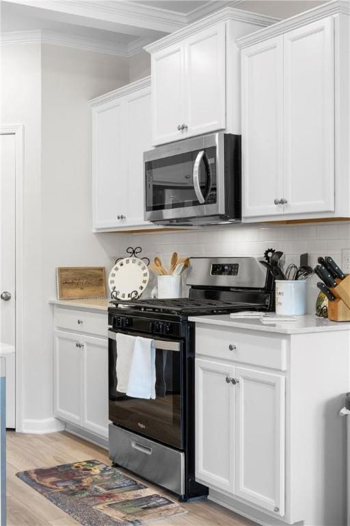 2144 Covey Dr, Auburn, AL 36879 - kitchen with appliances with stainless steel finishes, ornamental molding, light countertops, decorative backsplash, and white cabinetry