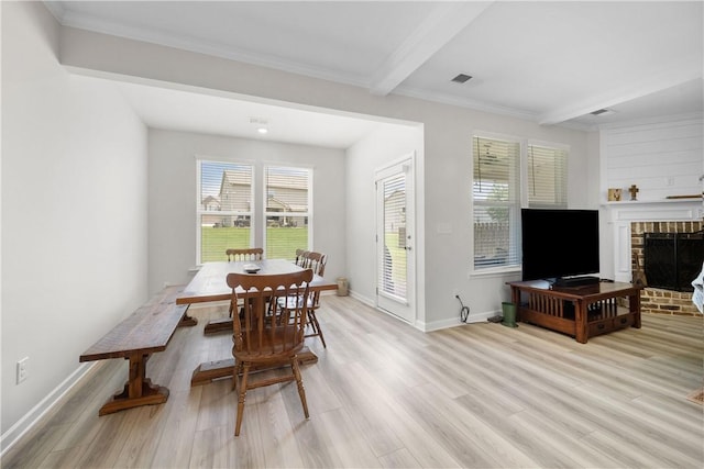 2144 Covey Dr, Auburn, AL 36879 - dining room with healthy amount of natural light, light wood finished floors, a brick fireplace, beamed ceiling, and ornamental molding
