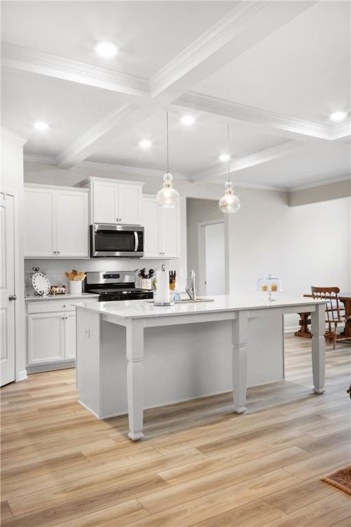 2144 Covey Dr, Auburn, AL 36879 - kitchen featuring appliances with stainless steel finishes, beam ceiling, coffered ceiling, a breakfast bar, and light wood-style flooring