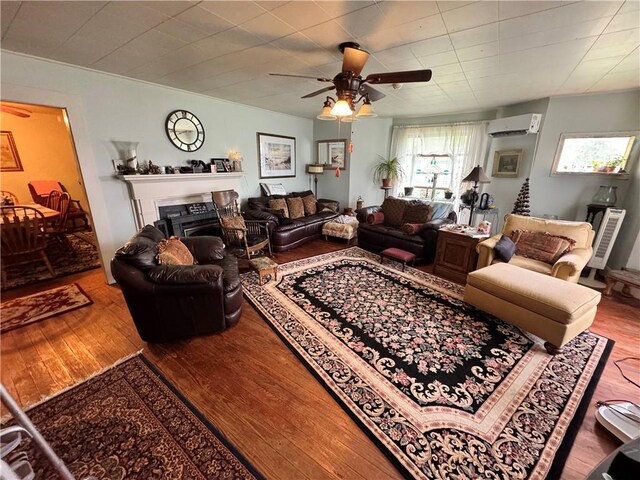 108 Carr St, Tallassee, AL 36078 - living room with a wall mounted air conditioner, wood finished floors, ceiling fan, and a fireplace