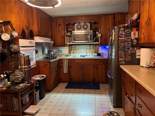 108 Carr St, Tallassee, AL 36078 - kitchen with stainless steel appliances, a sink, under cabinet range hood, light flooring, and light countertops