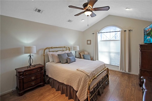 bedroom with a ceiling fan, visible vents, vaulted ceiling, and wood finished floors