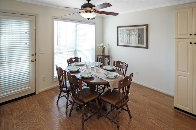 dining space with a ceiling fan, ornamental molding, baseboards, and wood finished floors