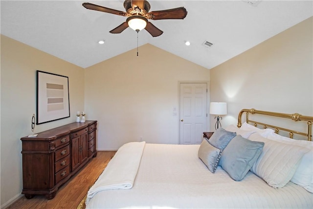 bedroom featuring light wood-style floors, visible vents, vaulted ceiling, and baseboards
