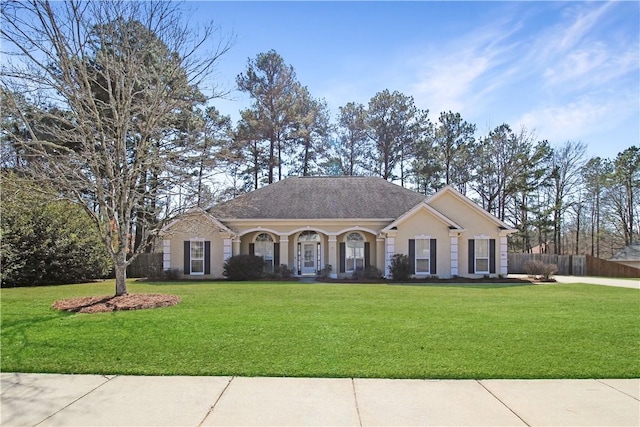 view of front facade featuring a front yard, fence, and stucco siding