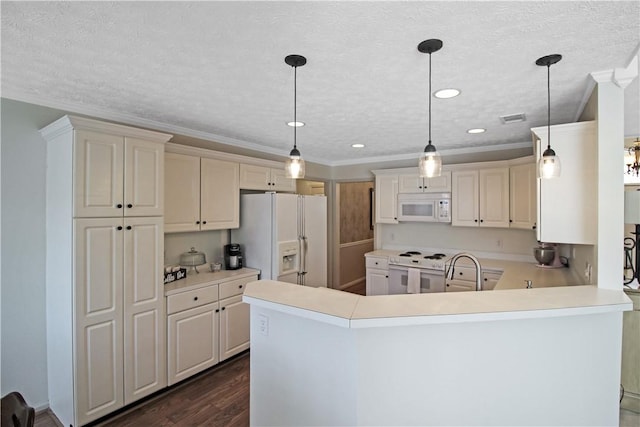 kitchen featuring a peninsula, white appliances, light countertops, and decorative light fixtures