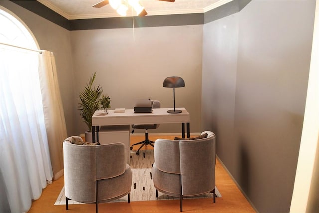 home office with light wood-type flooring, crown molding, and ceiling fan