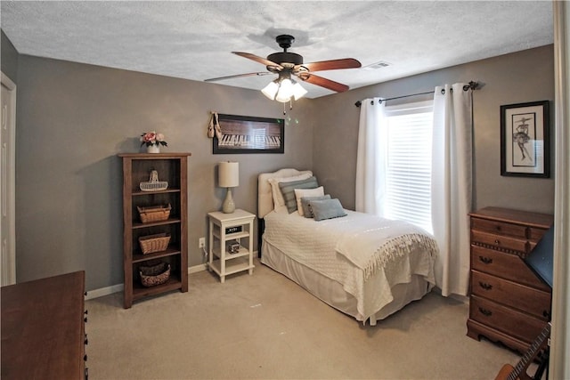 bedroom with visible vents, baseboards, a textured ceiling, and light colored carpet