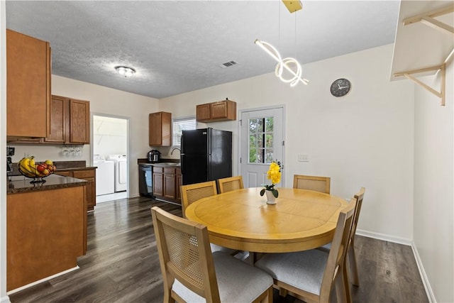 dining room featuring washer and clothes dryer, dark hardwood / wood-style floors, sink, and a textured ceiling