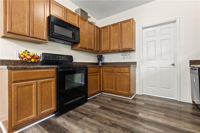 kitchen with dark wood-type flooring, black appliances, and a textured ceiling