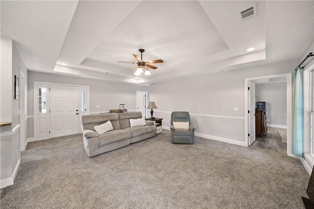 carpeted living area featuring a raised ceiling, baseboards, a ceiling fan, a textured ceiling, and recessed lighting