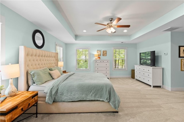 bedroom featuring baseboards, multiple windows, and a tray ceiling