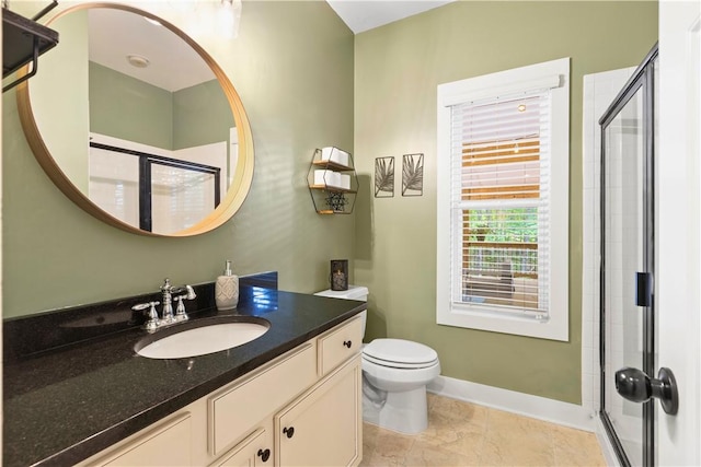 bathroom featuring vanity, baseboards, a stall shower, and toilet