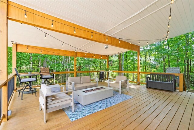 deck featuring an outdoor living space with a fire pit