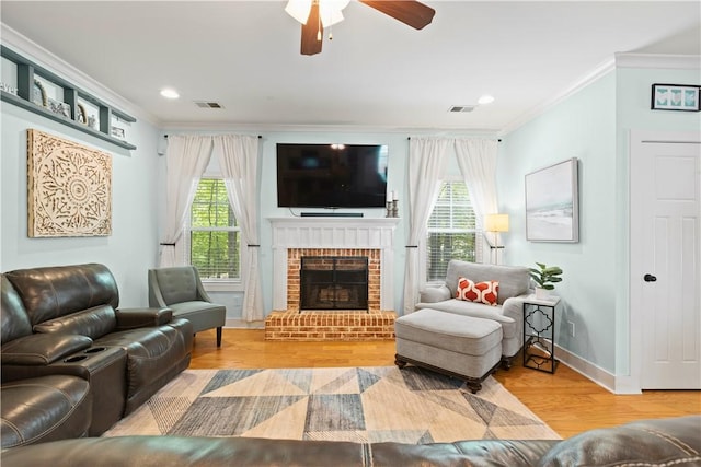living area with crown molding, ceiling fan, wood finished floors, and visible vents