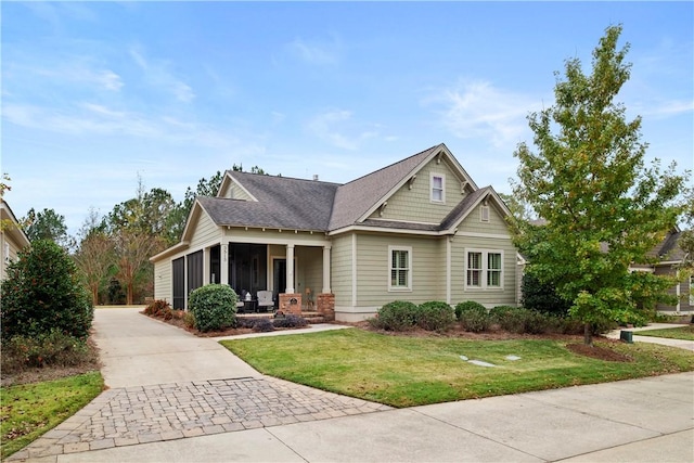 craftsman inspired home featuring a front lawn and a sunroom