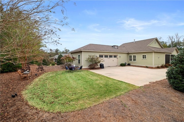 back of property with a yard and a garage