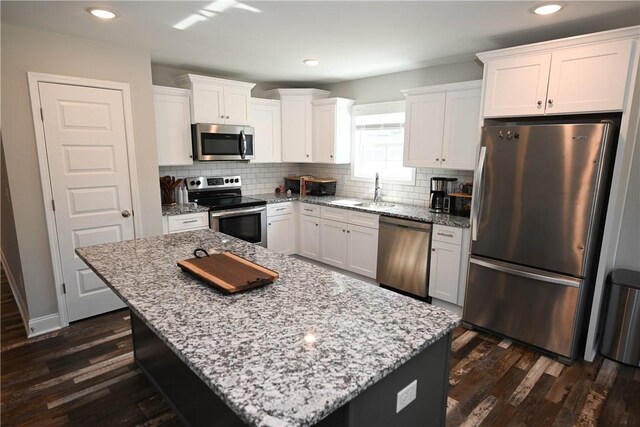 86 Lee Road 2229, Opelika, AL 36804 - kitchen with stainless steel appliances, a sink, decorative backsplash, white cabinets, and dark wood-type flooring