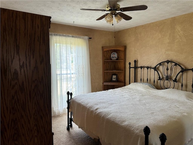 carpeted bedroom featuring ceiling fan and a textured ceiling