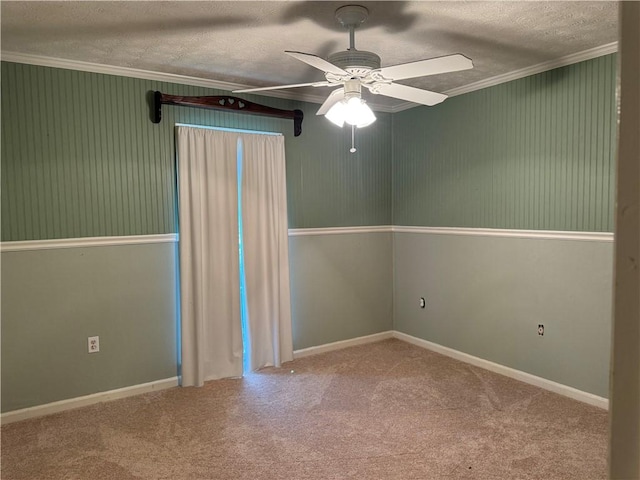 carpeted spare room featuring a textured ceiling, ceiling fan, and ornamental molding