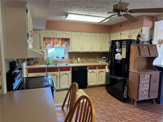 kitchen featuring black appliances, sink, ceiling fan, a textured ceiling, and cream cabinetry