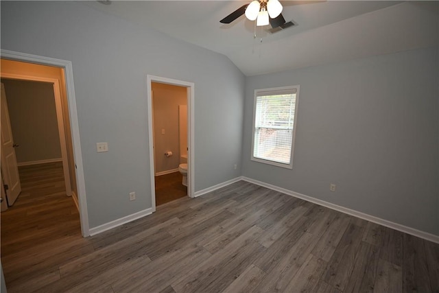 unfurnished bedroom featuring ceiling fan, dark hardwood / wood-style flooring, ensuite bathroom, and lofted ceiling