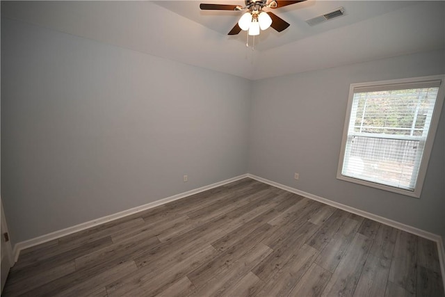 spare room with dark hardwood / wood-style flooring and ceiling fan