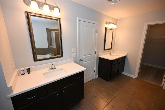 bathroom featuring tile patterned flooring, vanity, and walk in shower