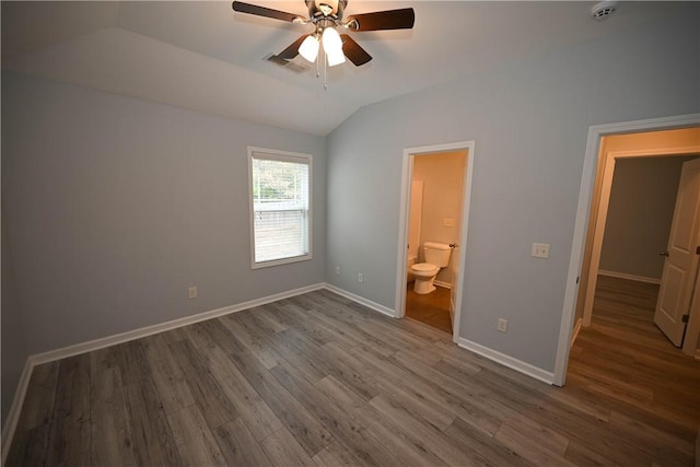 unfurnished bedroom featuring lofted ceiling, ensuite bathroom, ceiling fan, and hardwood / wood-style flooring