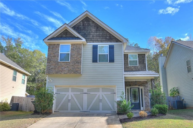 view of front of house featuring a front yard, central AC unit, and a garage