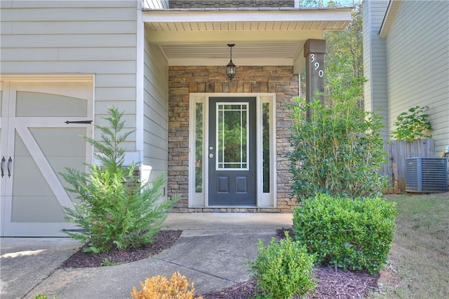 doorway to property featuring central AC unit and a garage