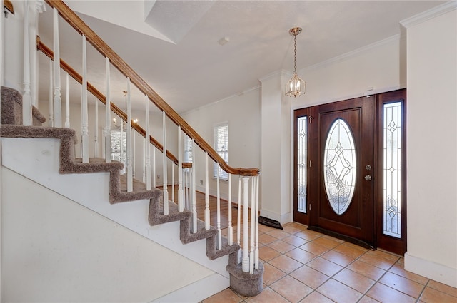 foyer entrance with ornamental molding and light tile patterned floors