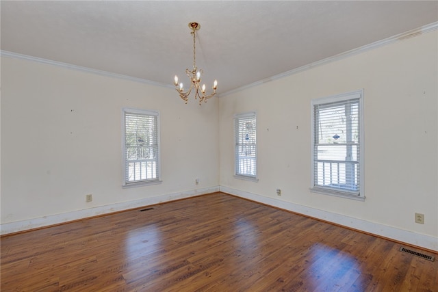 spare room featuring an inviting chandelier, crown molding, and dark hardwood / wood-style floors