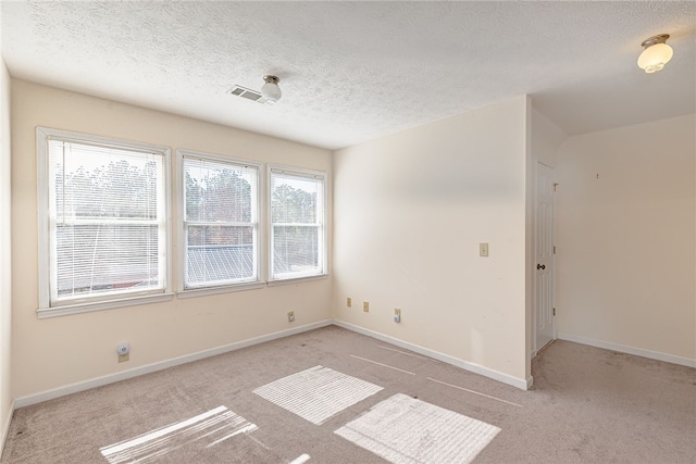 carpeted empty room featuring a textured ceiling