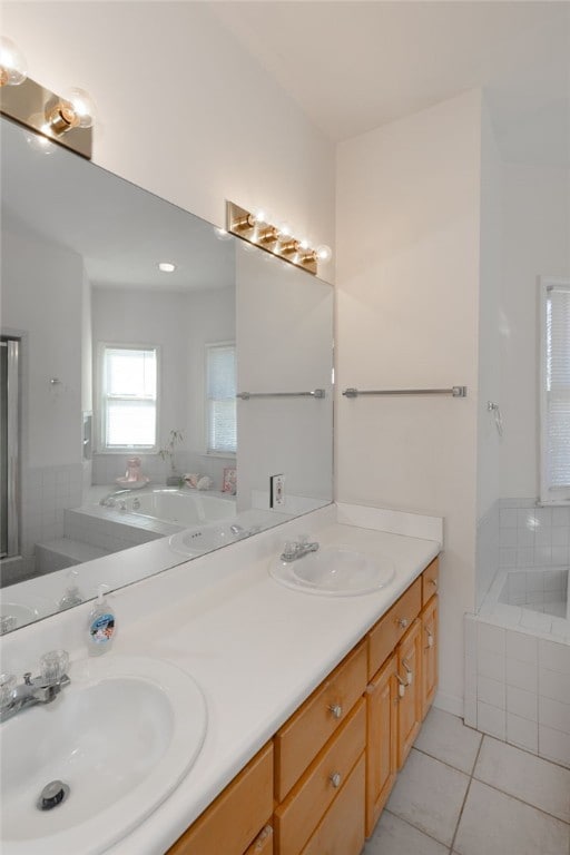 bathroom with tile patterned flooring, vanity, and a relaxing tiled tub