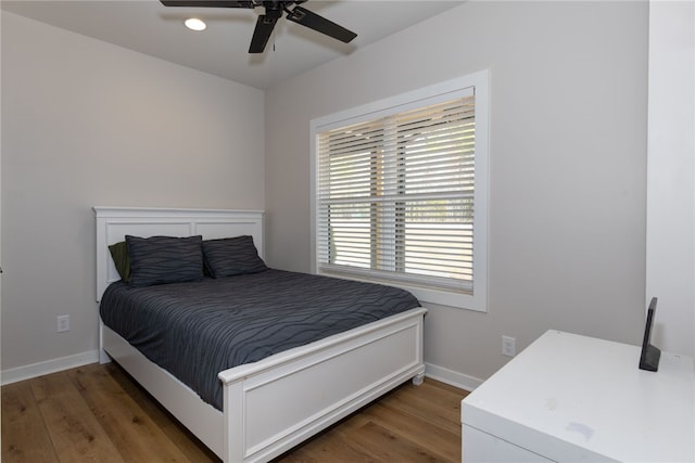 bedroom featuring dark wood finished floors, a ceiling fan, and baseboards