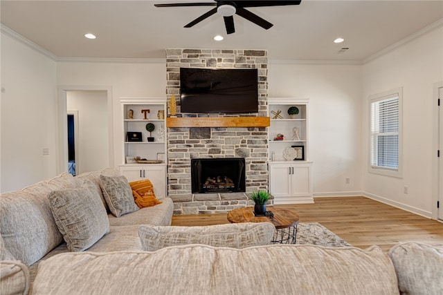 living room with baseboards, a ceiling fan, ornamental molding, light wood-type flooring, and a fireplace