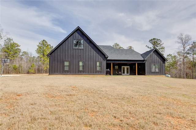 modern farmhouse featuring roof with shingles, a front lawn, board and batten siding, and french doors