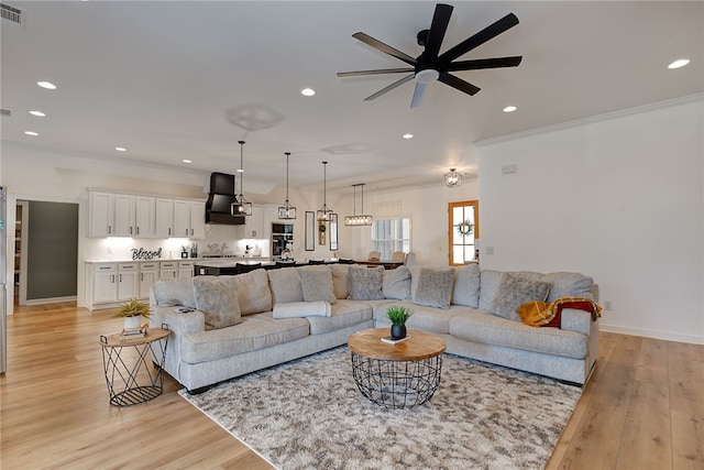 living room with recessed lighting, light wood-style flooring, and crown molding