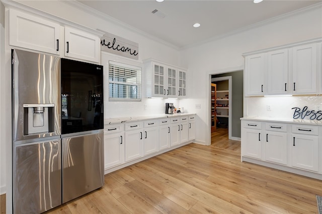 kitchen with stainless steel fridge, glass insert cabinets, and white cabinets