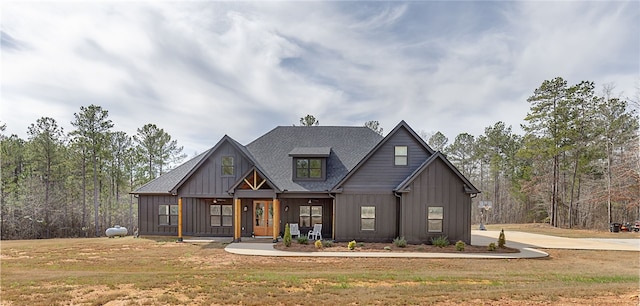 modern farmhouse style home with a front lawn and board and batten siding