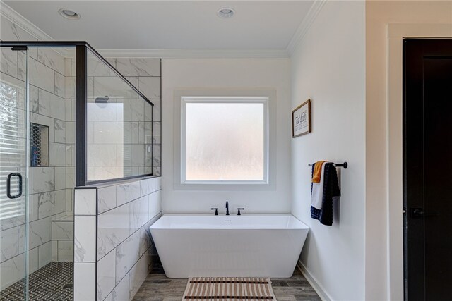 full bathroom with a stall shower, a healthy amount of sunlight, crown molding, and a freestanding bath