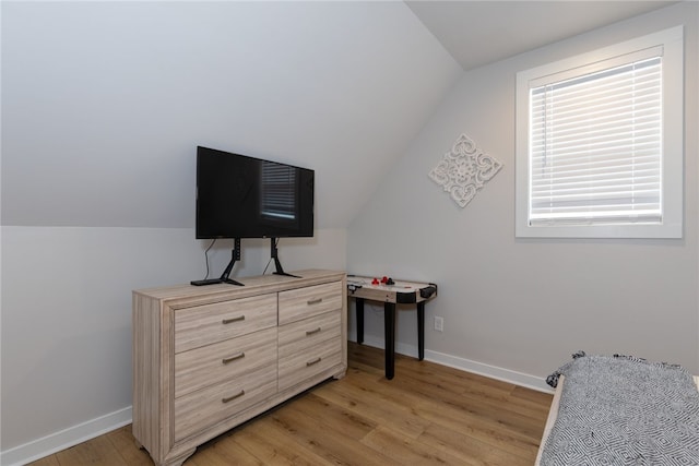 bedroom featuring lofted ceiling, light wood finished floors, and baseboards