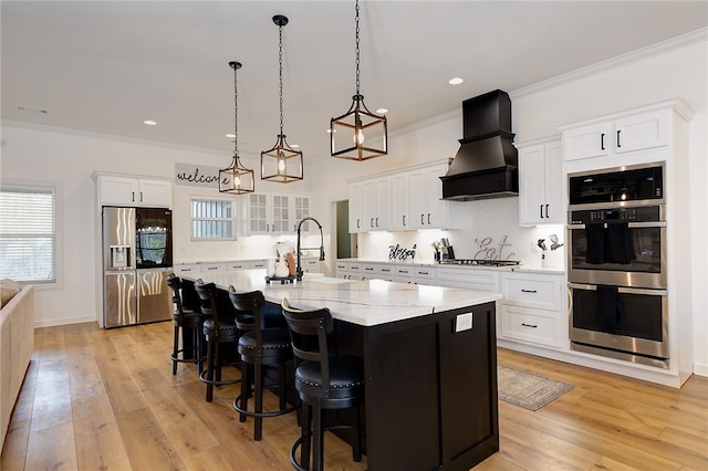 kitchen with stainless steel appliances, a spacious island, glass insert cabinets, white cabinetry, and premium range hood