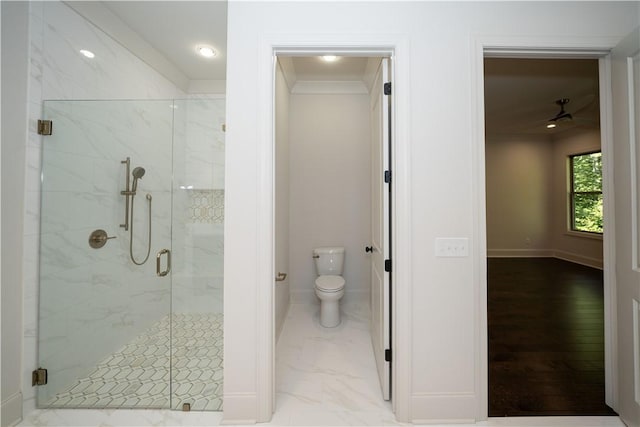 bathroom with toilet, a shower with door, and crown molding