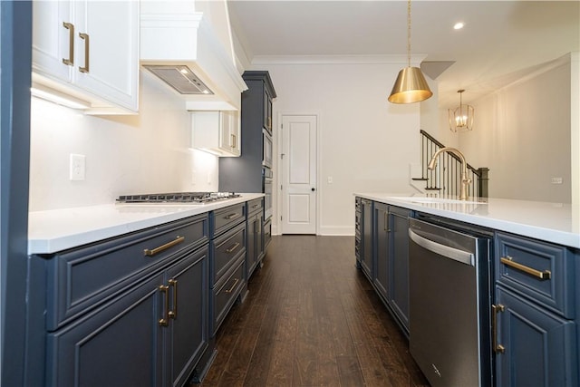 kitchen featuring pendant lighting, white cabinetry, blue cabinetry, and appliances with stainless steel finishes