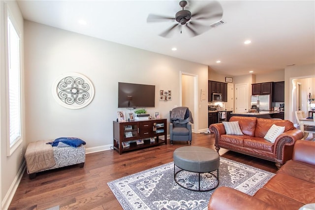 living room featuring dark hardwood / wood-style flooring and ceiling fan