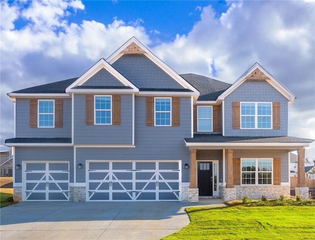 craftsman inspired home featuring a garage and a front yard